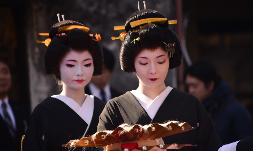 A pair of geisha wait to perform onstage in the coastal resort of Atami.